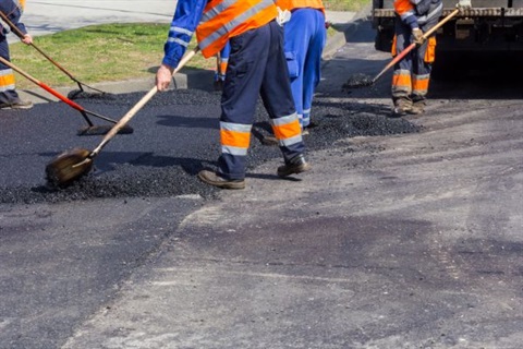 Working on the Road - Roadworkers asphalting and repairing the road.d